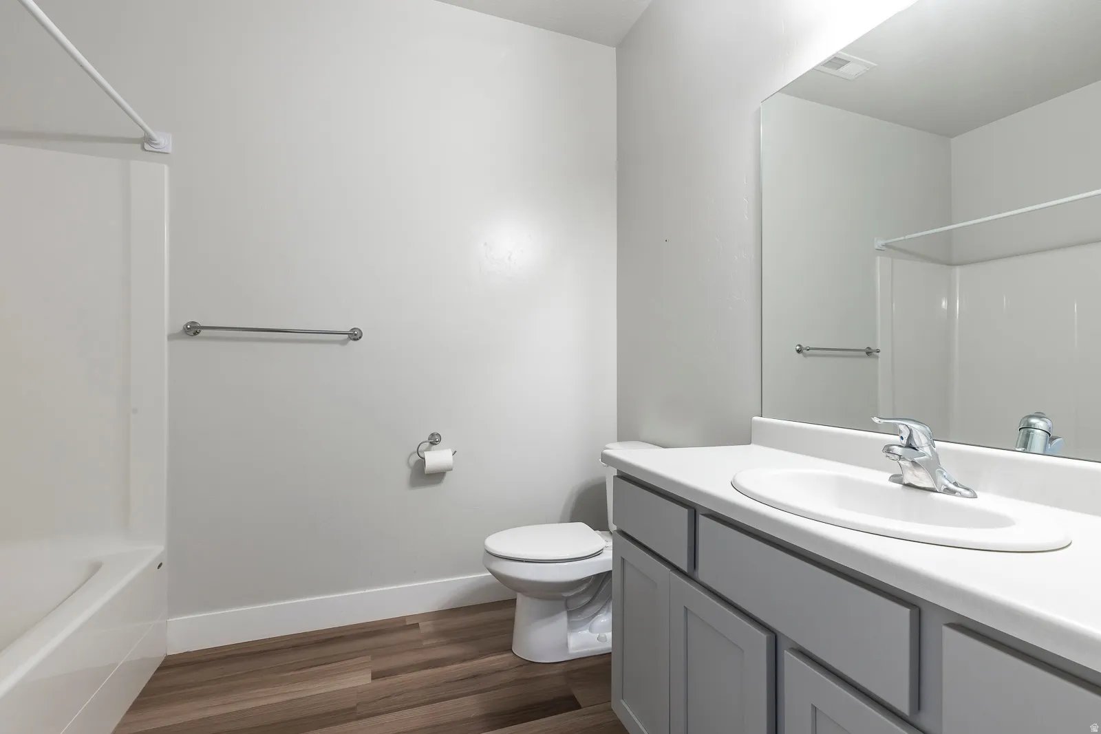 Full bathroom with vanity, tub / shower combination, and dark wood-style flooring