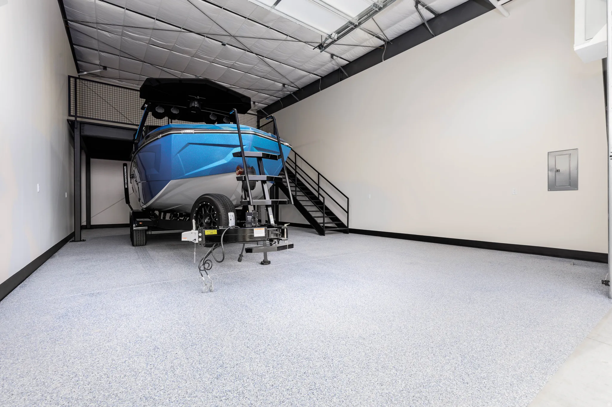 Garage with baseboards and electric panel
