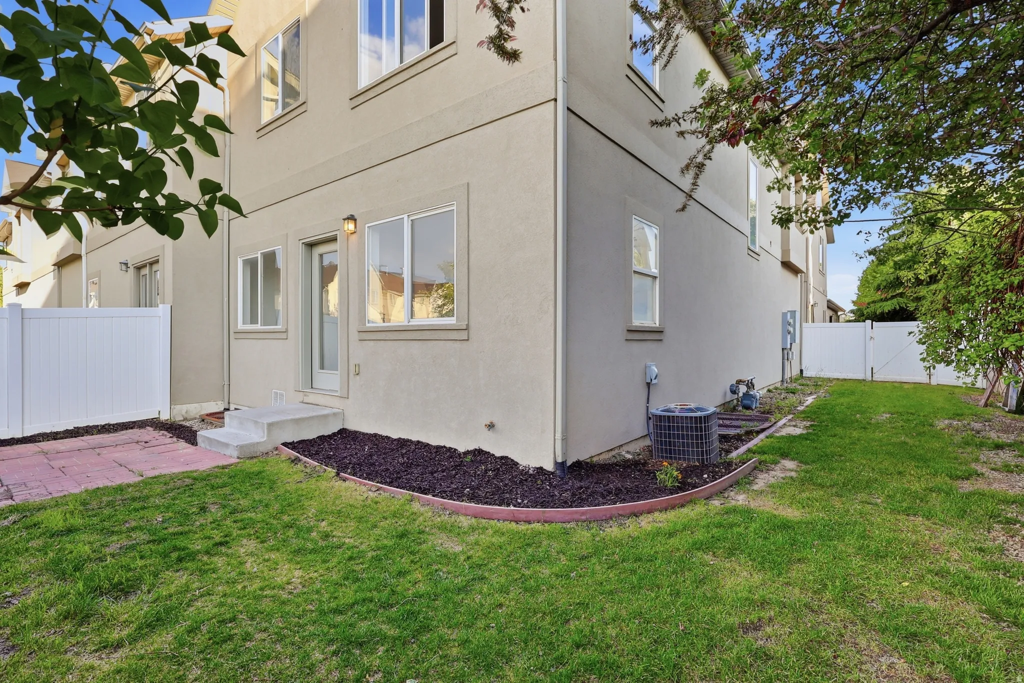 View of side of property with a fenced backyard, stucco siding, and a gate