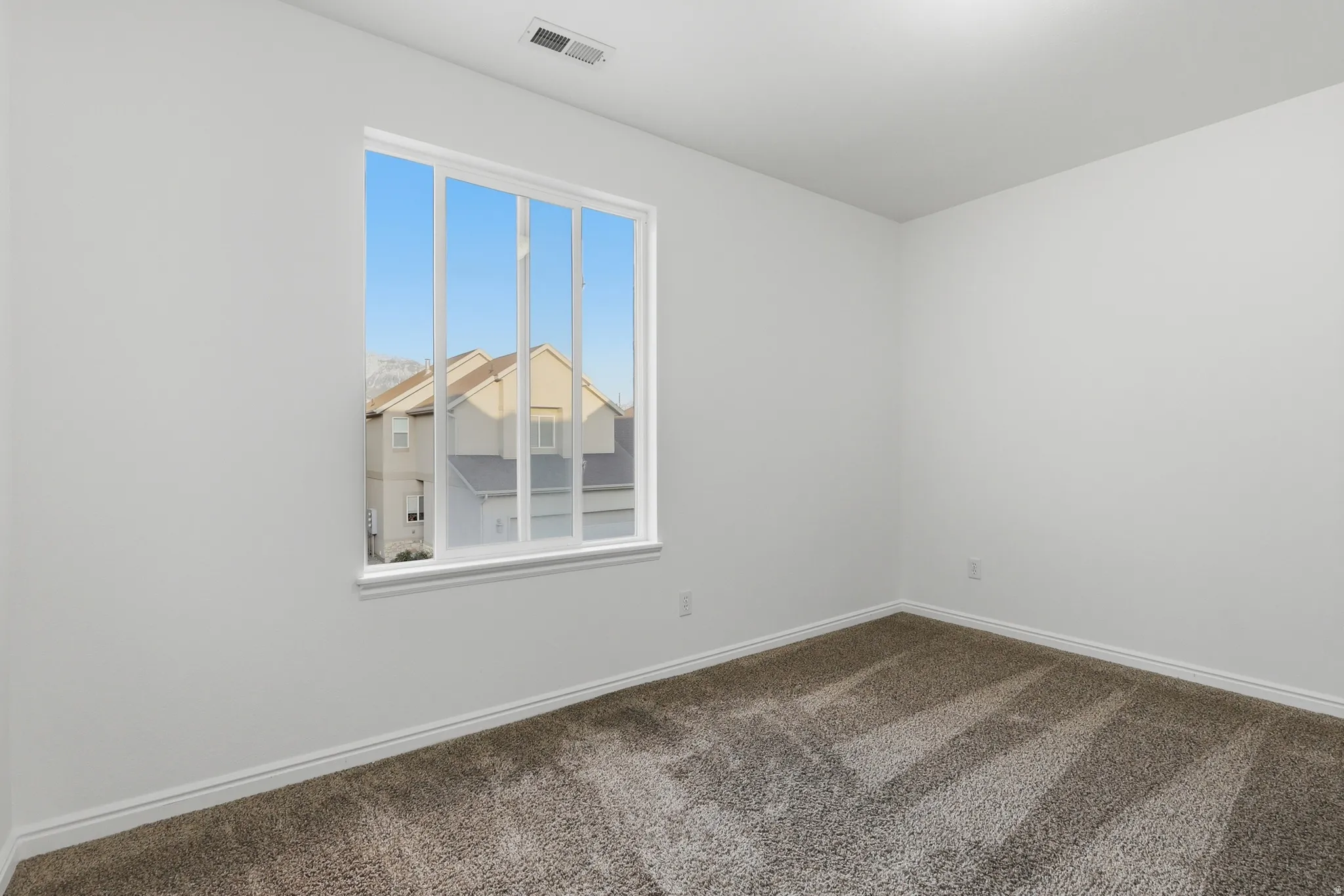 Empty room featuring baseboards and dark carpet