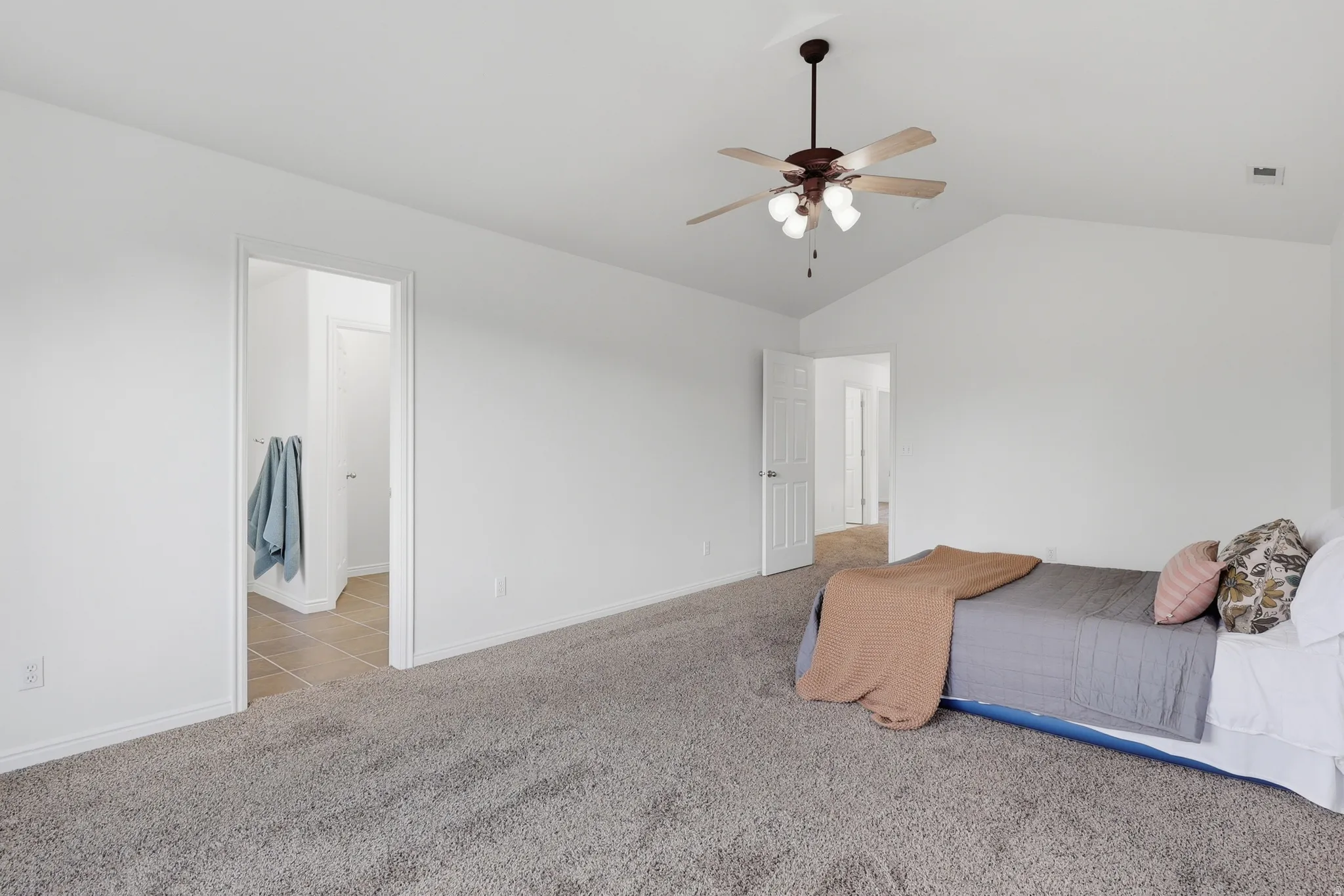 Unfurnished bedroom with light carpet, lofted ceiling, and ceiling fan
