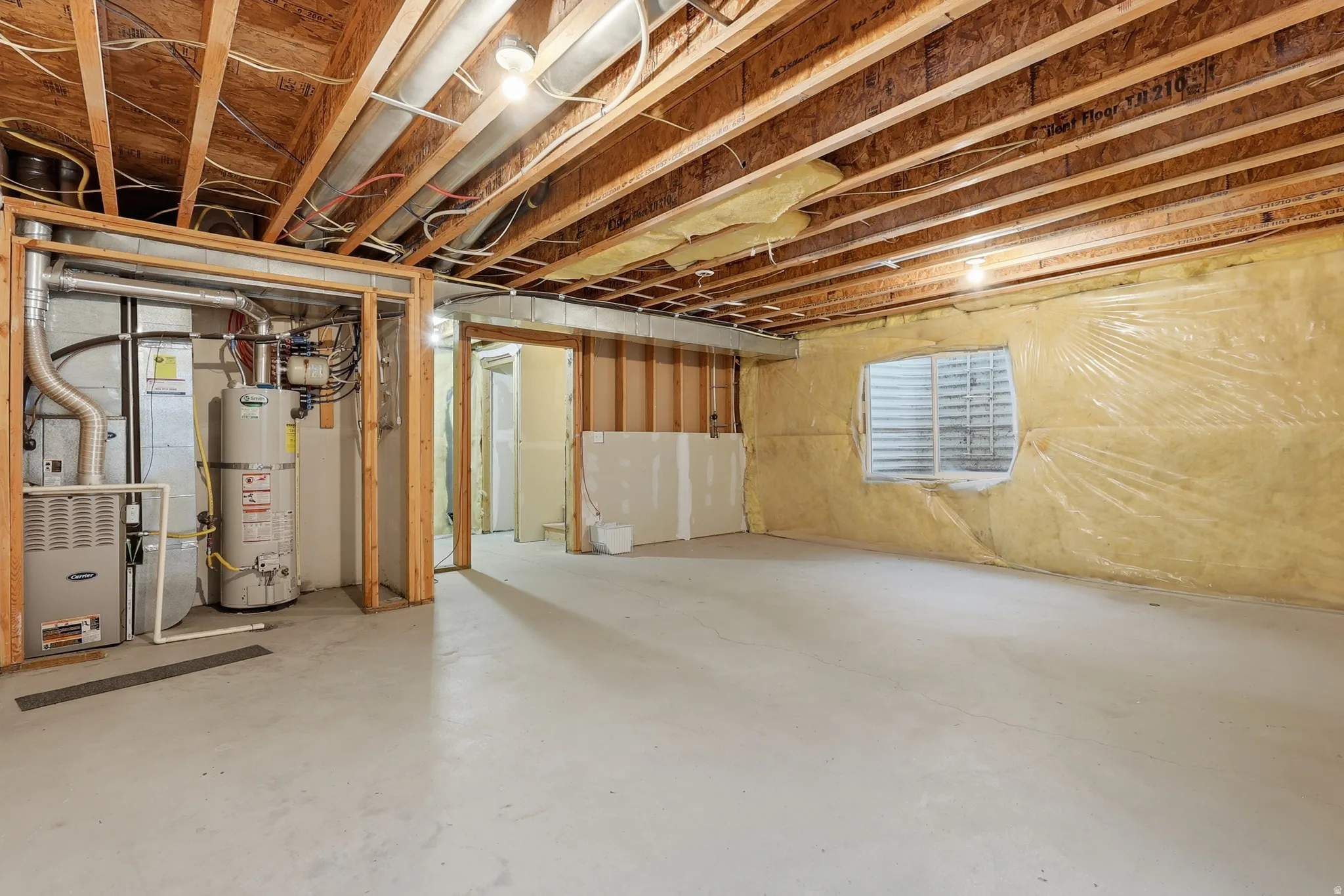 Below grade area featuring strapped water heater and heating unit