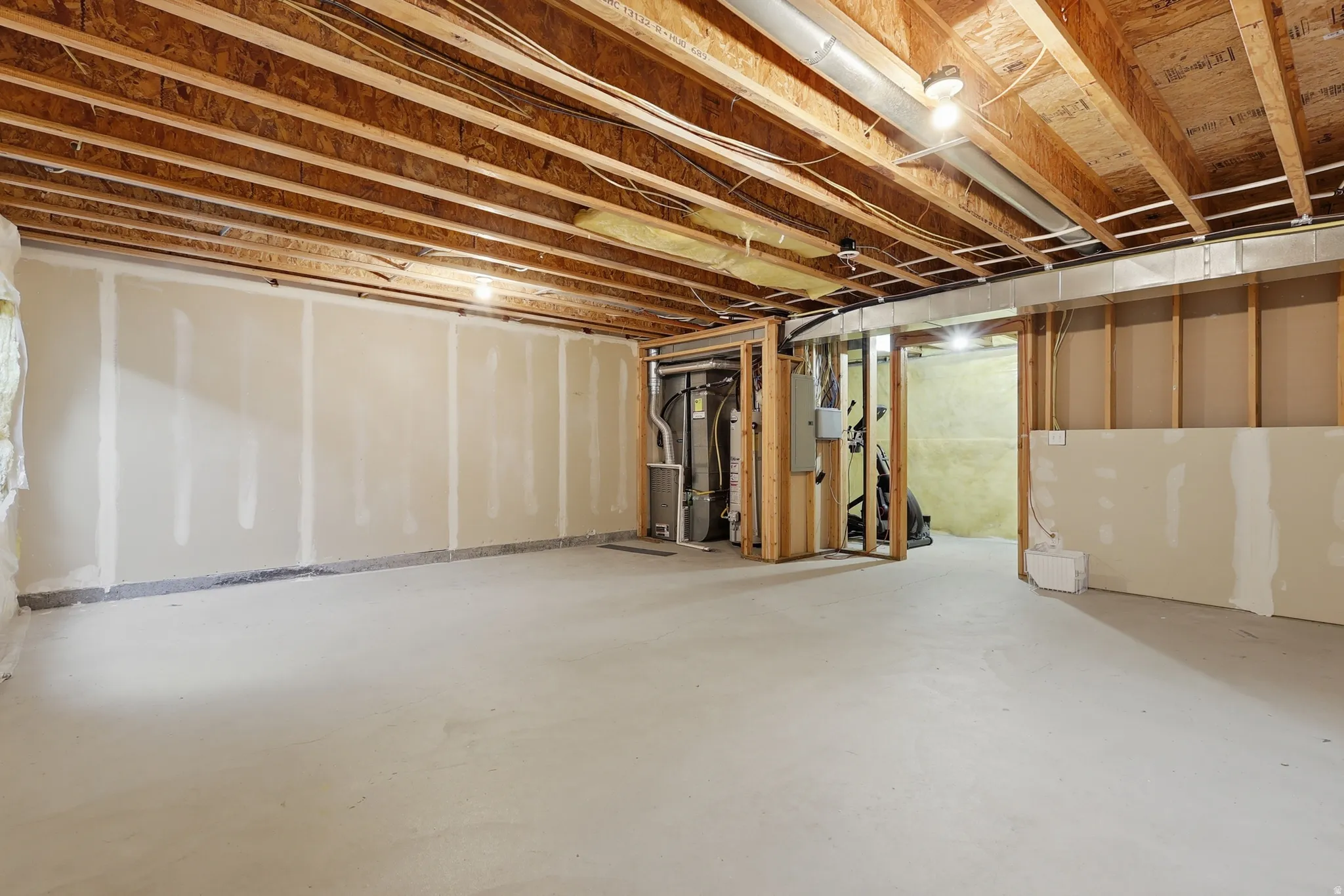 Unfinished below grade area featuring heating unit