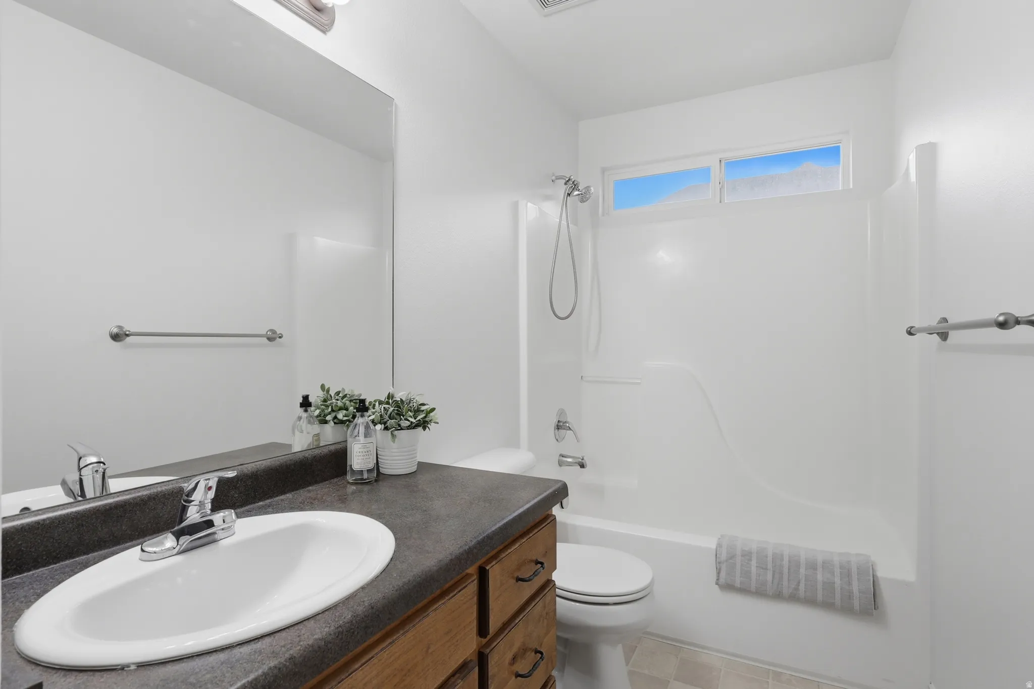 Bathroom with vanity and shower / washtub combination