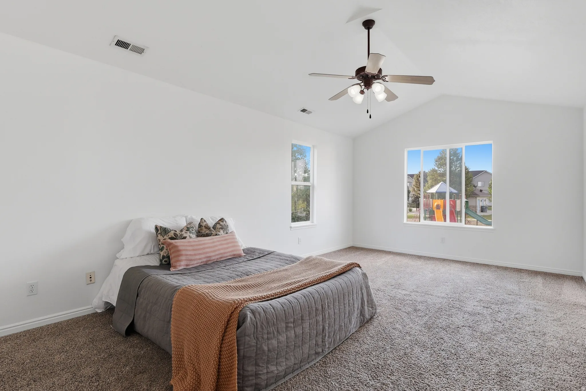 Carpeted bedroom with a ceiling fan and baseboards
