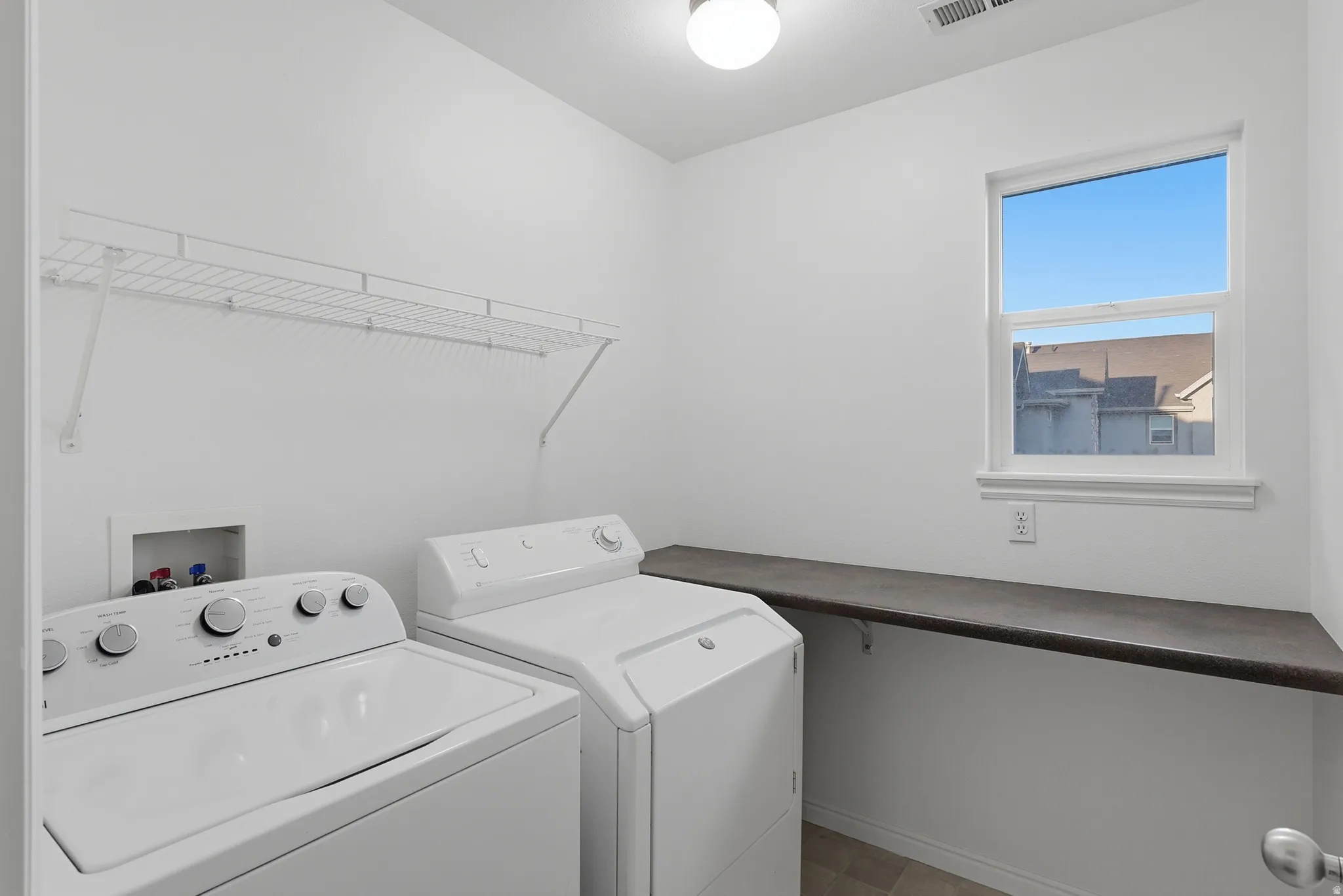 Laundry area with separate washer and dryer and baseboards