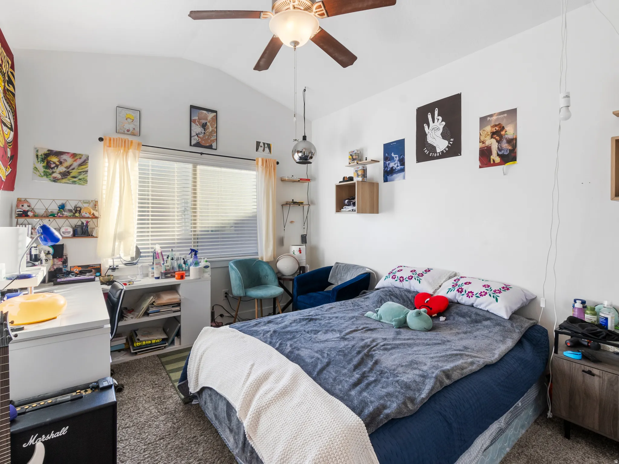 Carpeted bedroom featuring vaulted ceiling and a ceiling fan