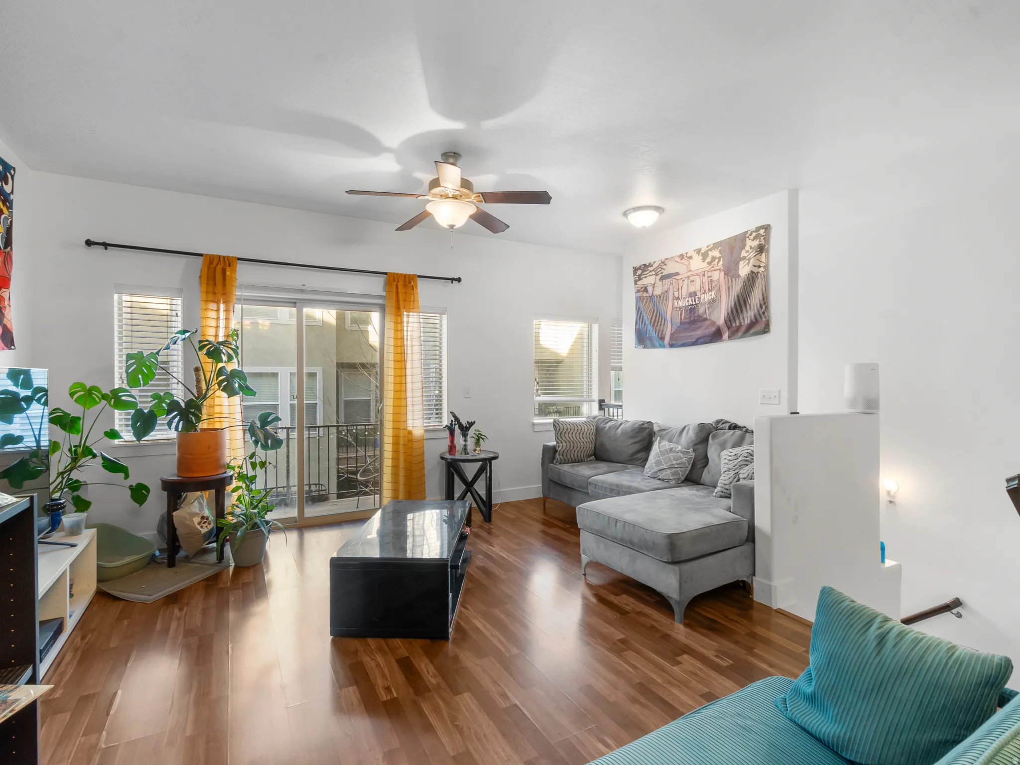 Living area with wood finished floors and a ceiling fan