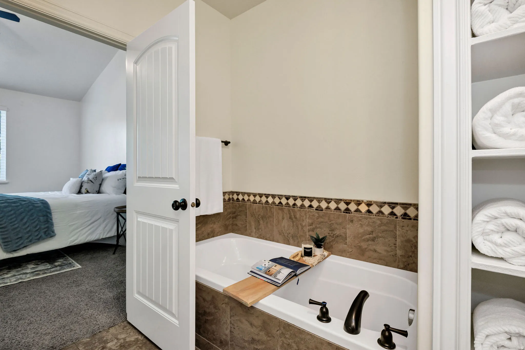Ensuite bathroom with a bath, dark carpet, and lofted ceiling
