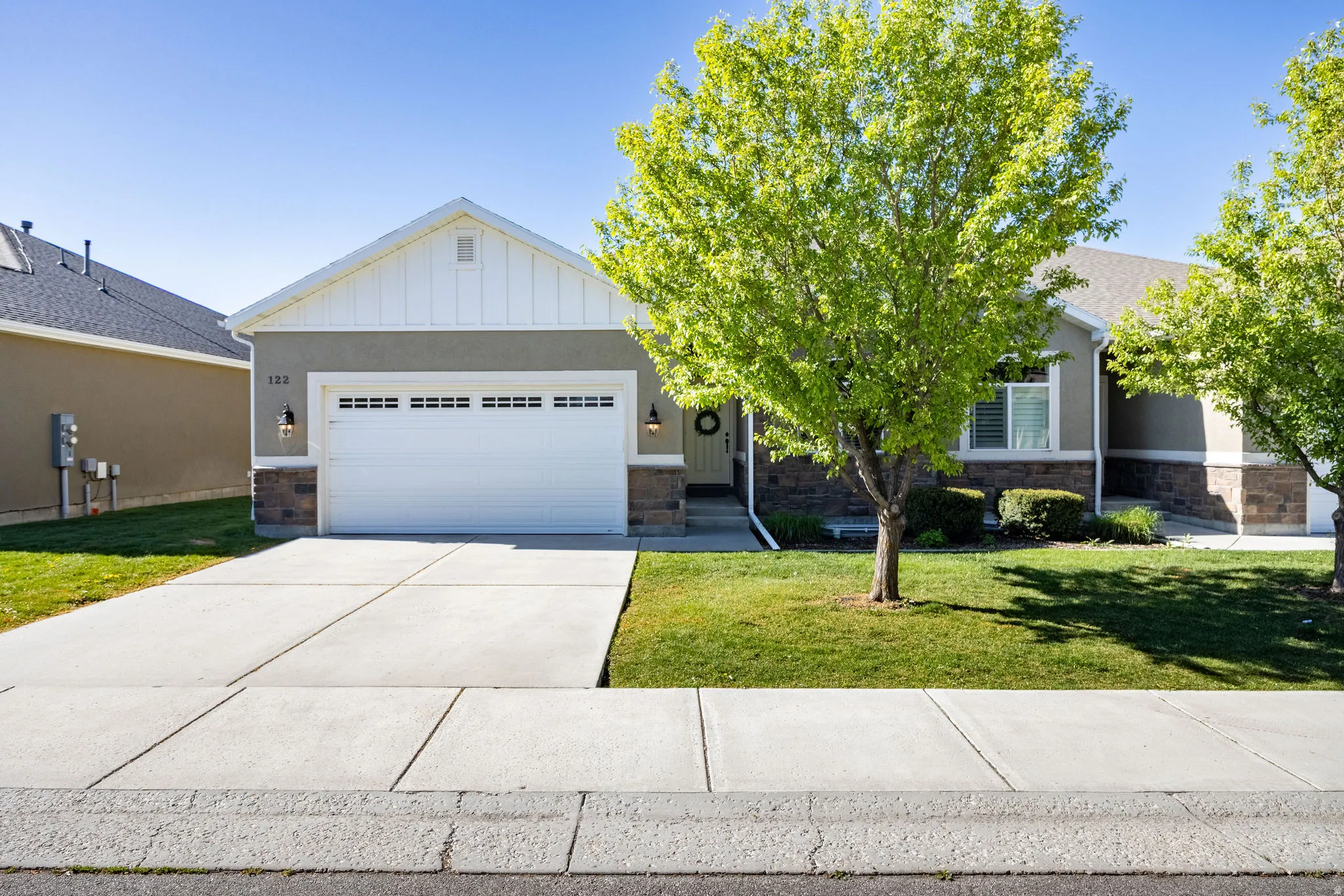 View of front of home with a front yard and stone siding