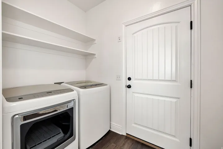 Laundry area featuring washer and dryer and dark wood-style floors