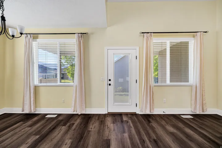 Doorway to back patio featuring wood finished floors and suspended lighting