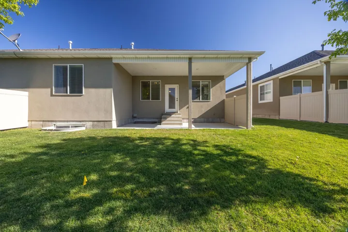 Rear view of house with stucco siding, a patio, and entry steps