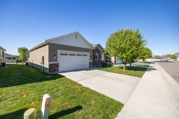 View of front of property featuring an attached garage, driveway, a front yard, and a residential view