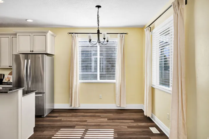 Dining area with suspended lighting, dark wood-style flooring