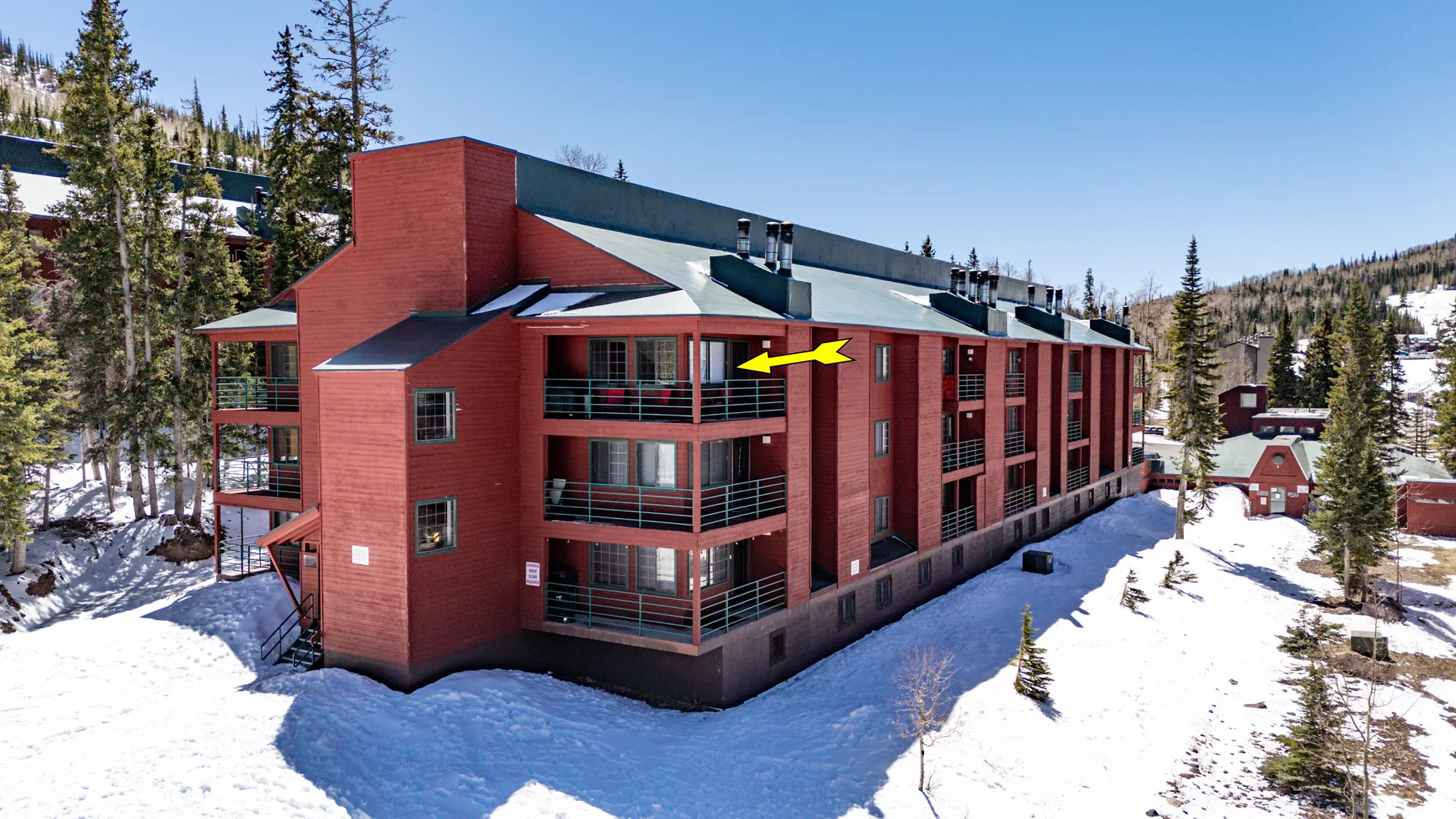 Snow covered building featuring a view of apartment building / complex