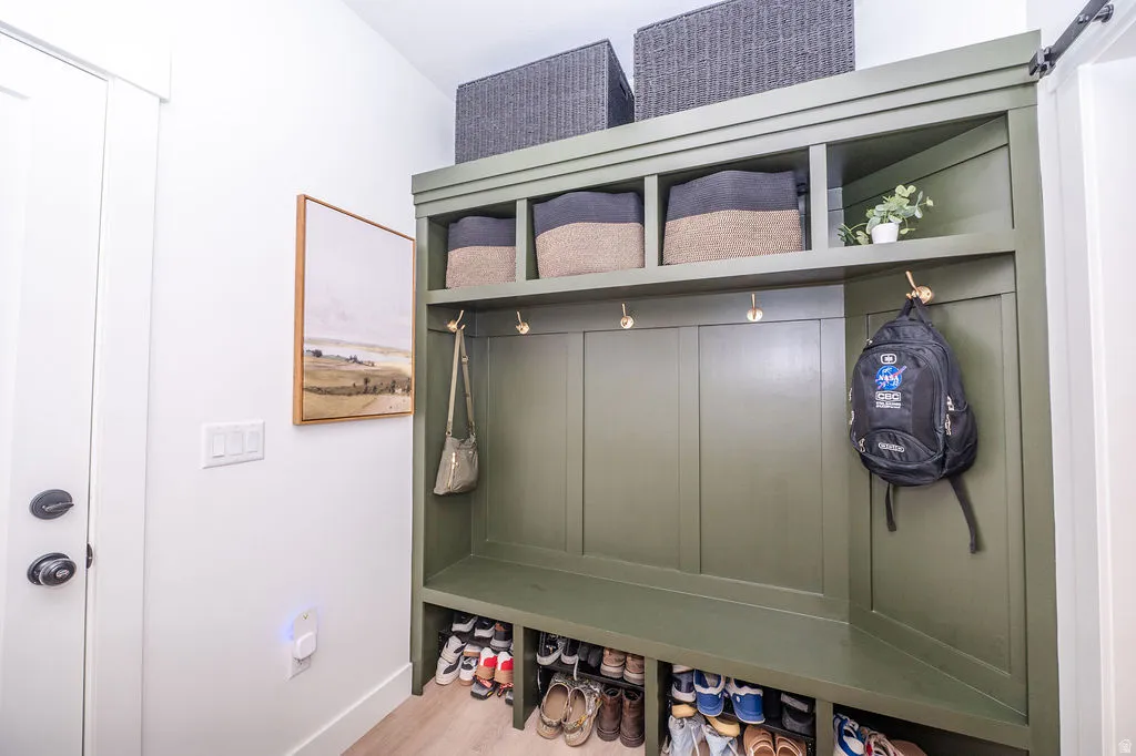 Mudroom featuring light wood-style floors and a barn door