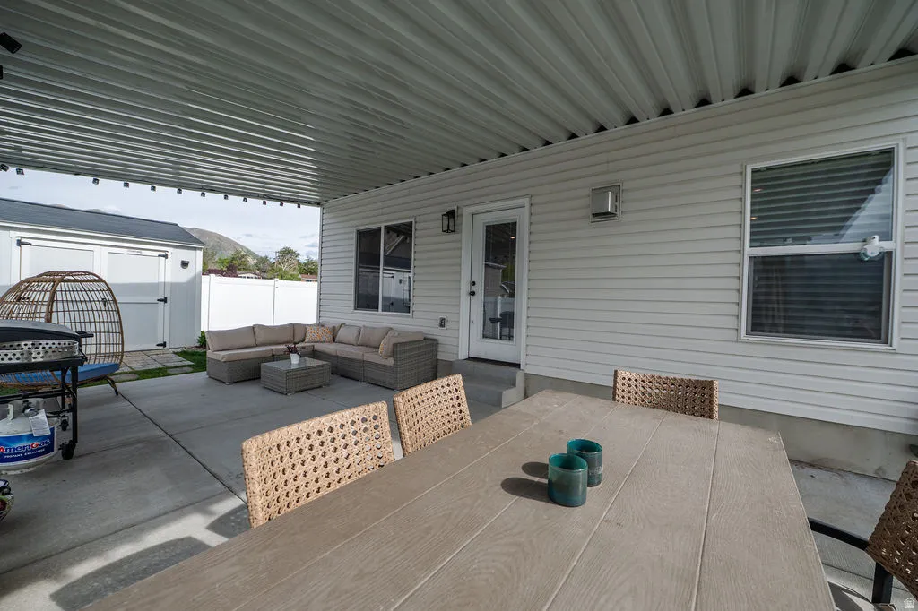 View of patio with outdoor lounge area and a shed