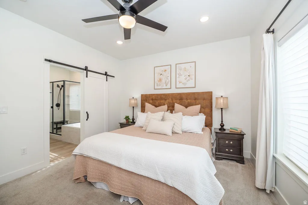 Bedroom featuring a barn door, carpet floors, recessed lighting, a ceiling fan, and connected bathroom
