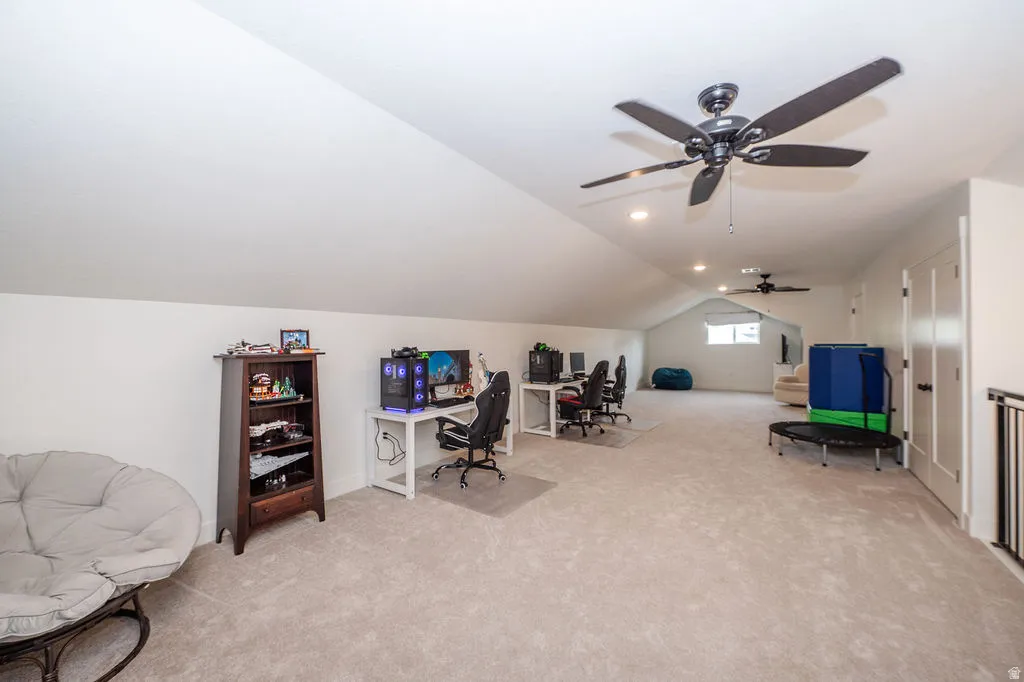Office with vaulted ceiling, light colored carpet, and ceiling fan