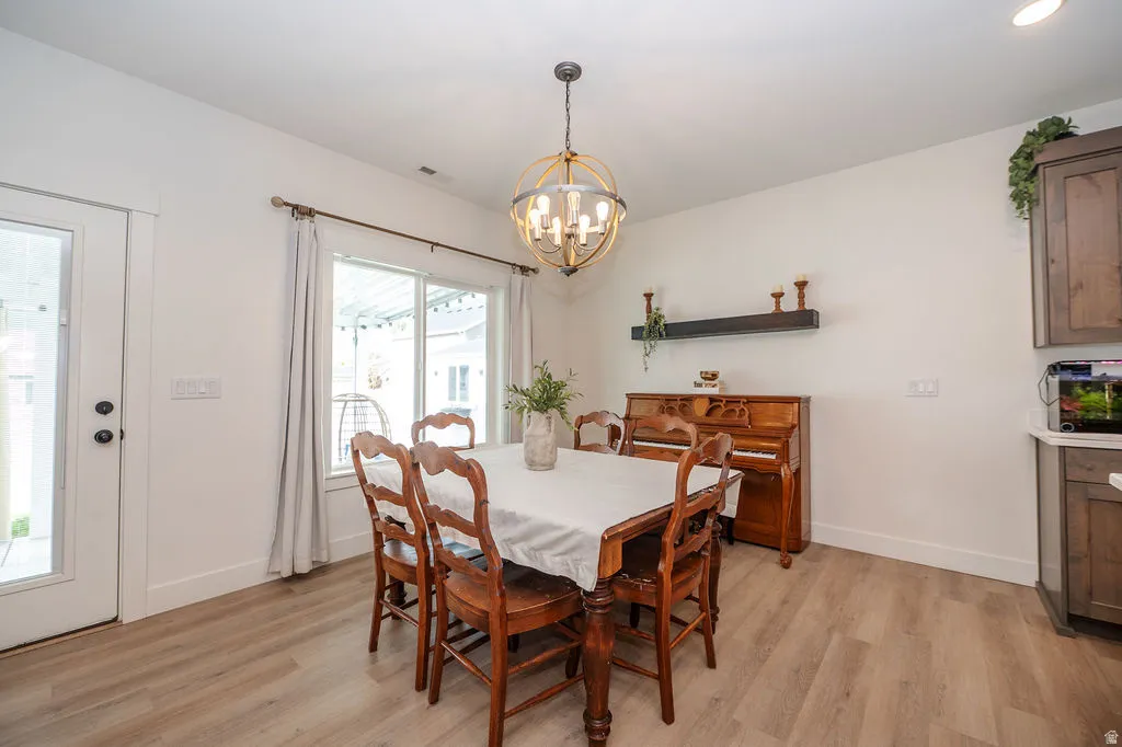 Dining space with light wood-style flooring and hanging lights