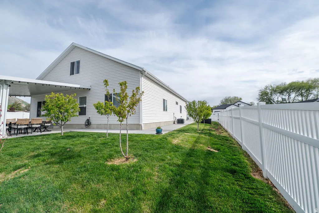 View of property exterior with a fenced backyard and a patio area