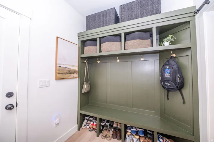 Mudroom featuring light wood-style floors and a barn door