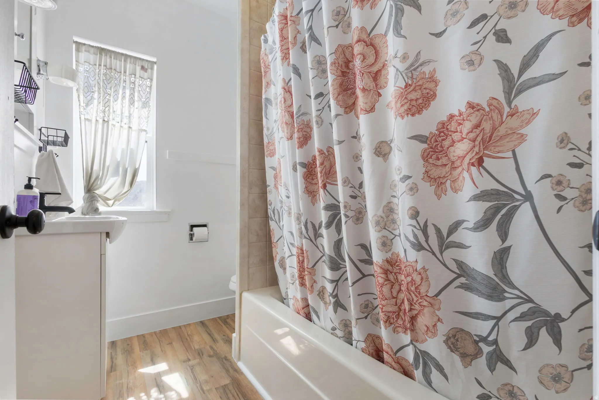 Full bathroom featuring light wood-style flooring, vanity, and shower / bath combo