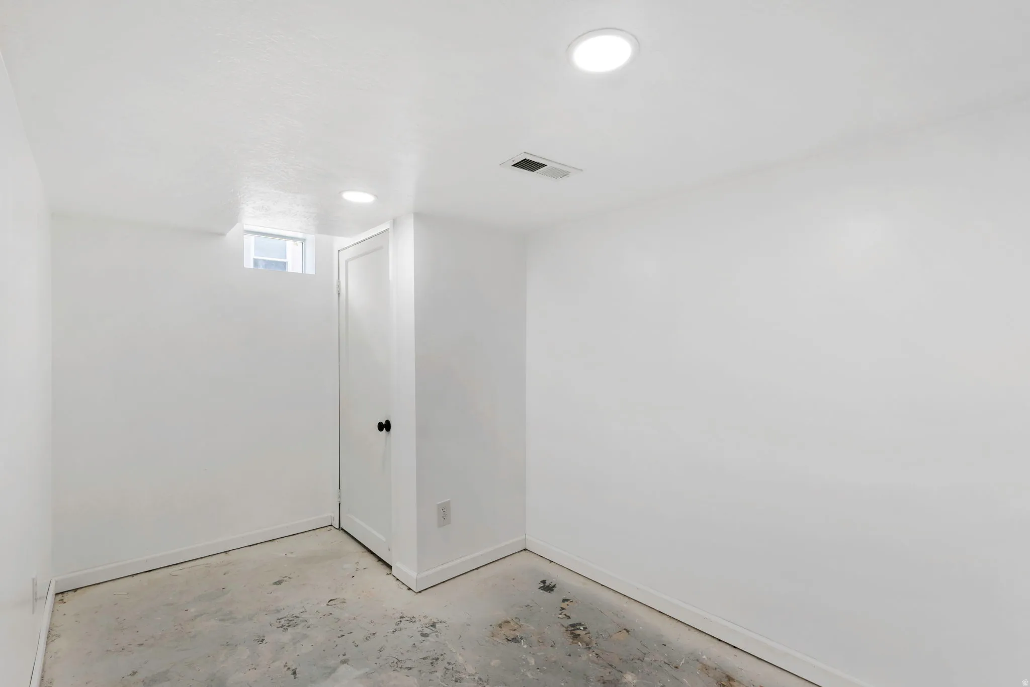 Empty room with concrete floors and recessed lighting
