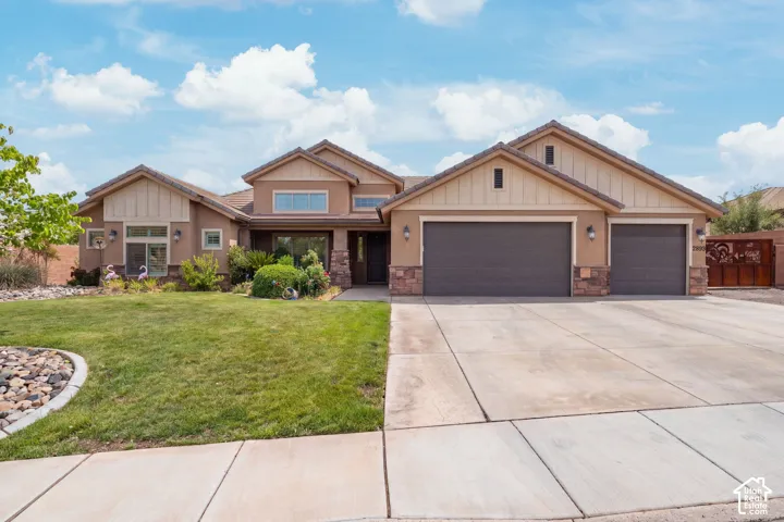 Single-story residence featuring a multi-gabled roofline, stone veneer accents, vertical siding details, a three-car garage, and a concrete driveway