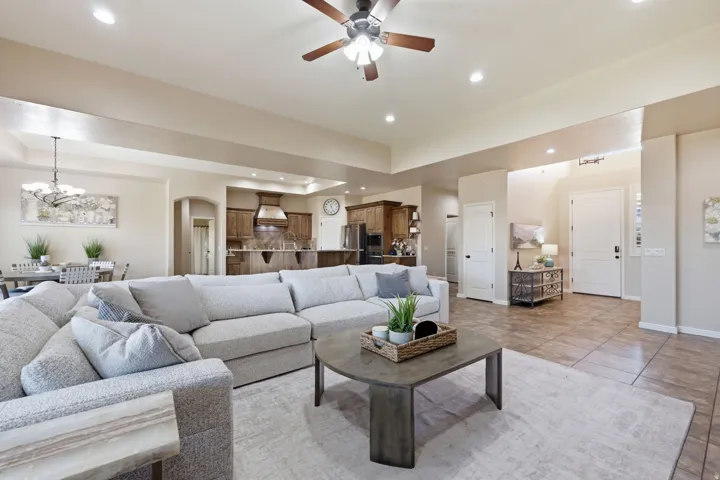 Expansive living area featuring recessed lighting, a ceiling fan, and tray ceilings