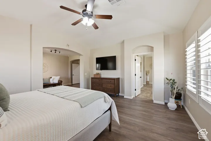 Wood-finish flooring throughout, complemented by arched doorways and ceiling fan