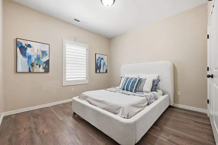 Spacious room featuring wood-finish flooring, neutral wall paint, and white baseboards