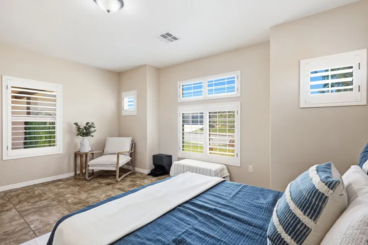 Neutral-toned walls complement multiple windows featuring white plantation shutters