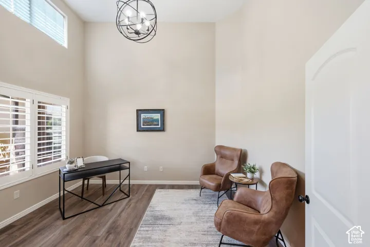 Vaulted ceilings, wood-finish flooring, plantation shutters, transom window, and orb-style chandelier