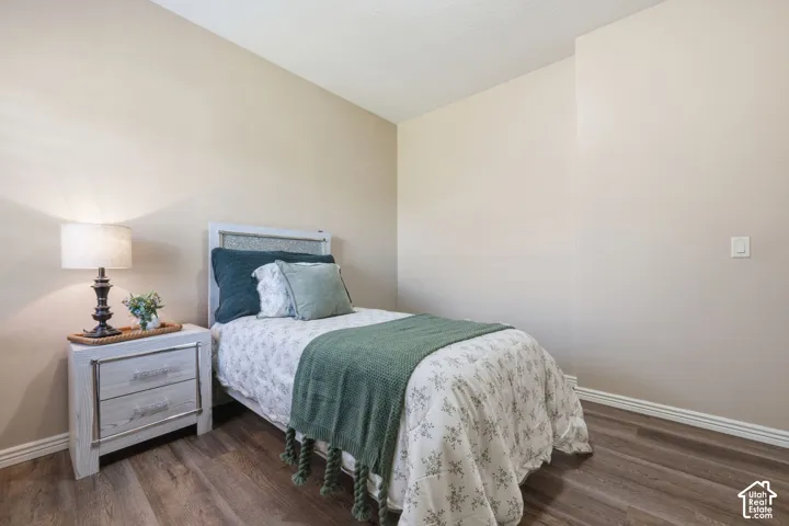 Bedroom featuring neutral wall paint, wood-finish flooring, and white baseboards