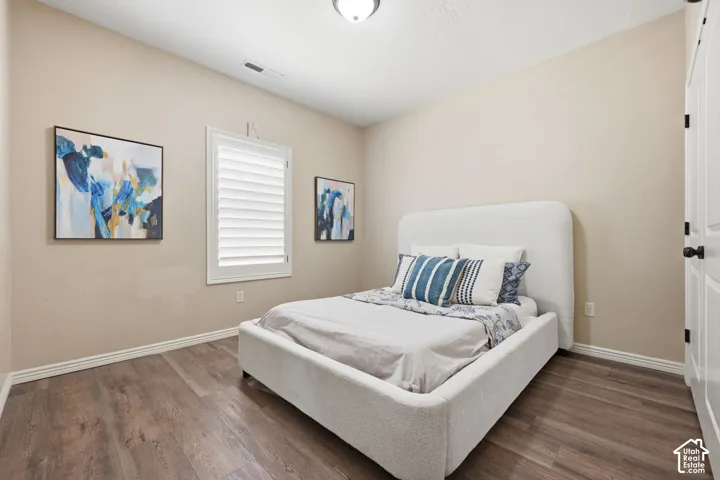 Spacious room featuring wood-finish flooring, neutral wall paint, and white baseboards
