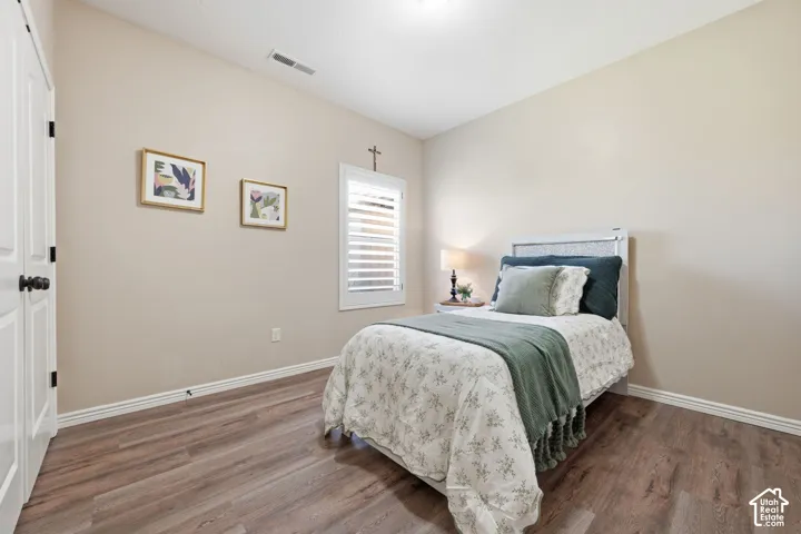 Room featuring wood-finish flooring, neutral wall tones, and white baseboards