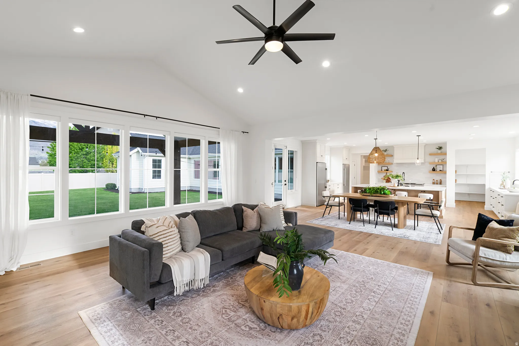 Living area featuring recessed lighting, light wood-style floors, ceiling fan, and vaulted ceiling