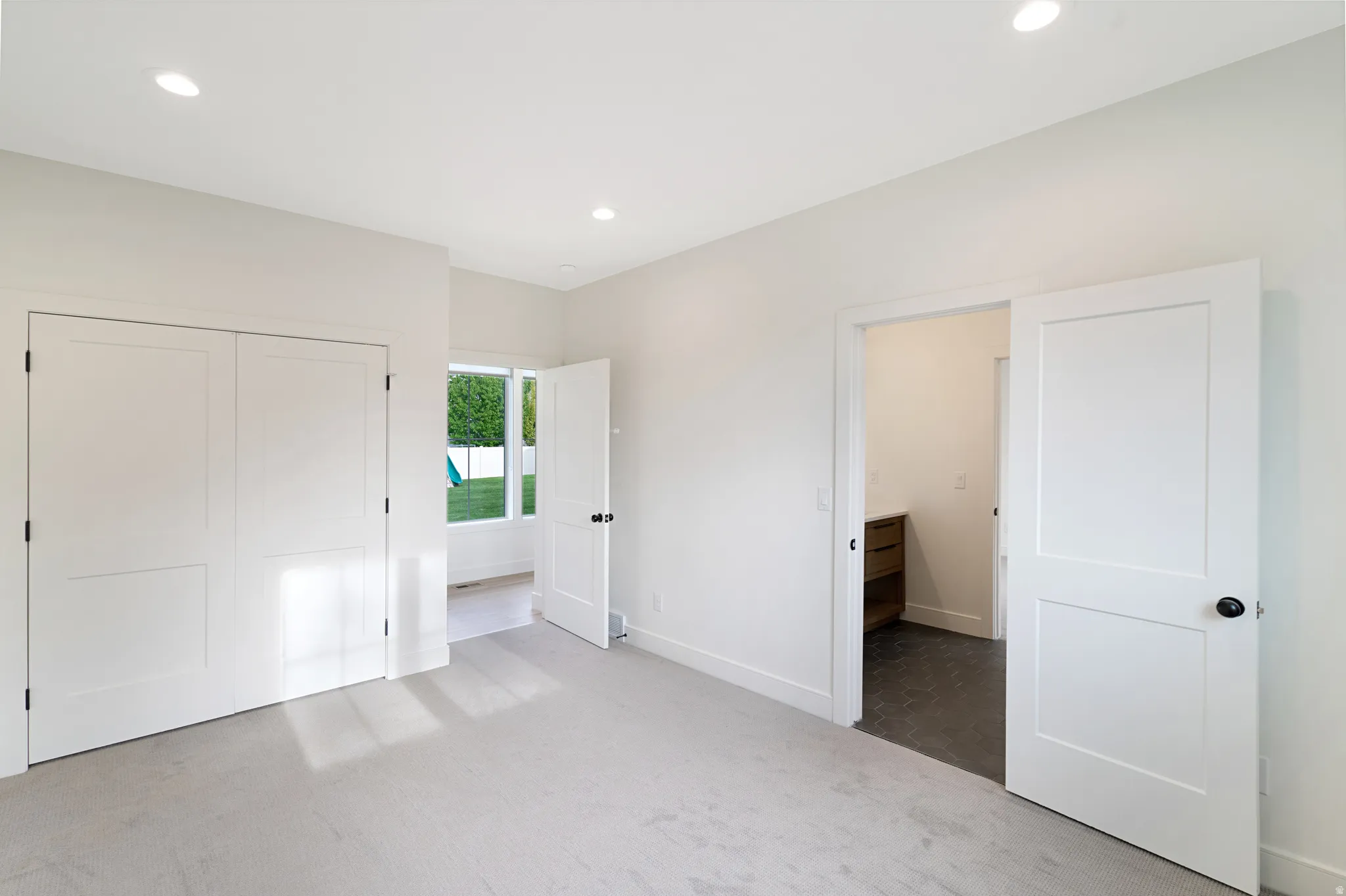 Unfurnished bedroom featuring light carpet, recessed lighting, and a closet