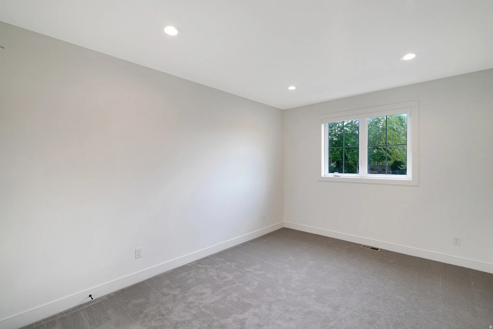 Spare room featuring light carpet and recessed lighting