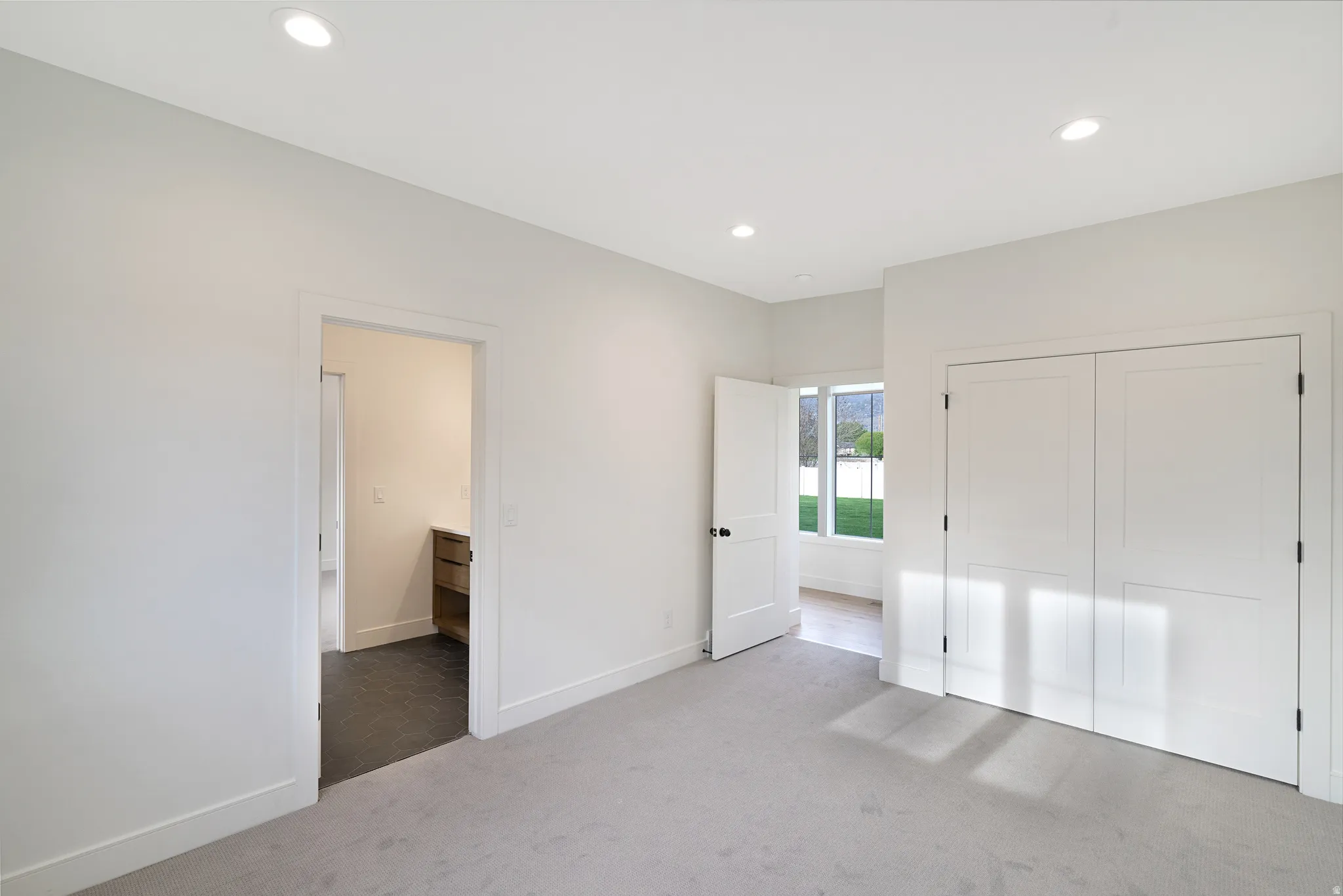 Unfurnished bedroom with light carpet, a closet, and recessed lighting
