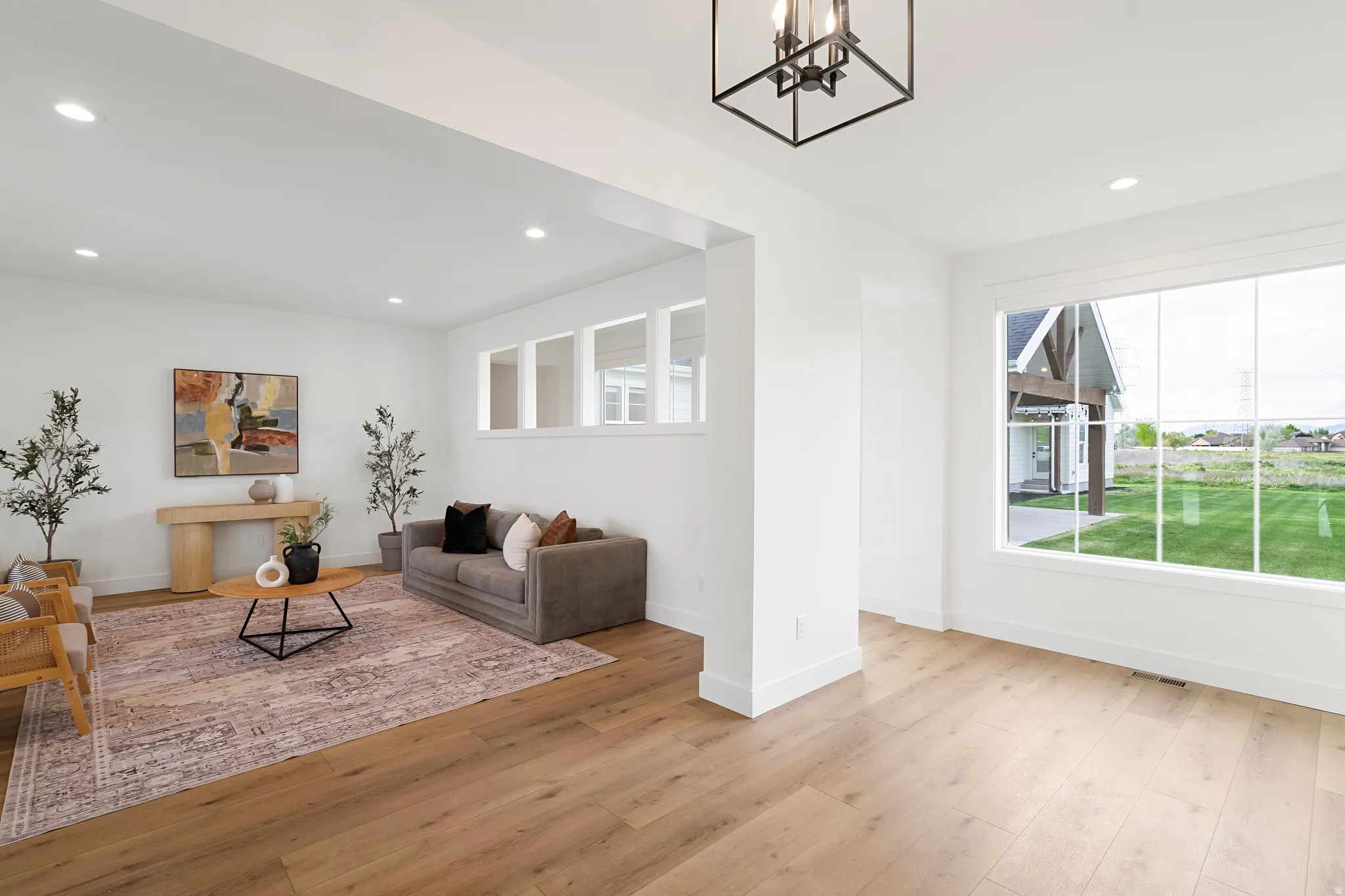 Living room featuring light wood-style floors and hanging lights