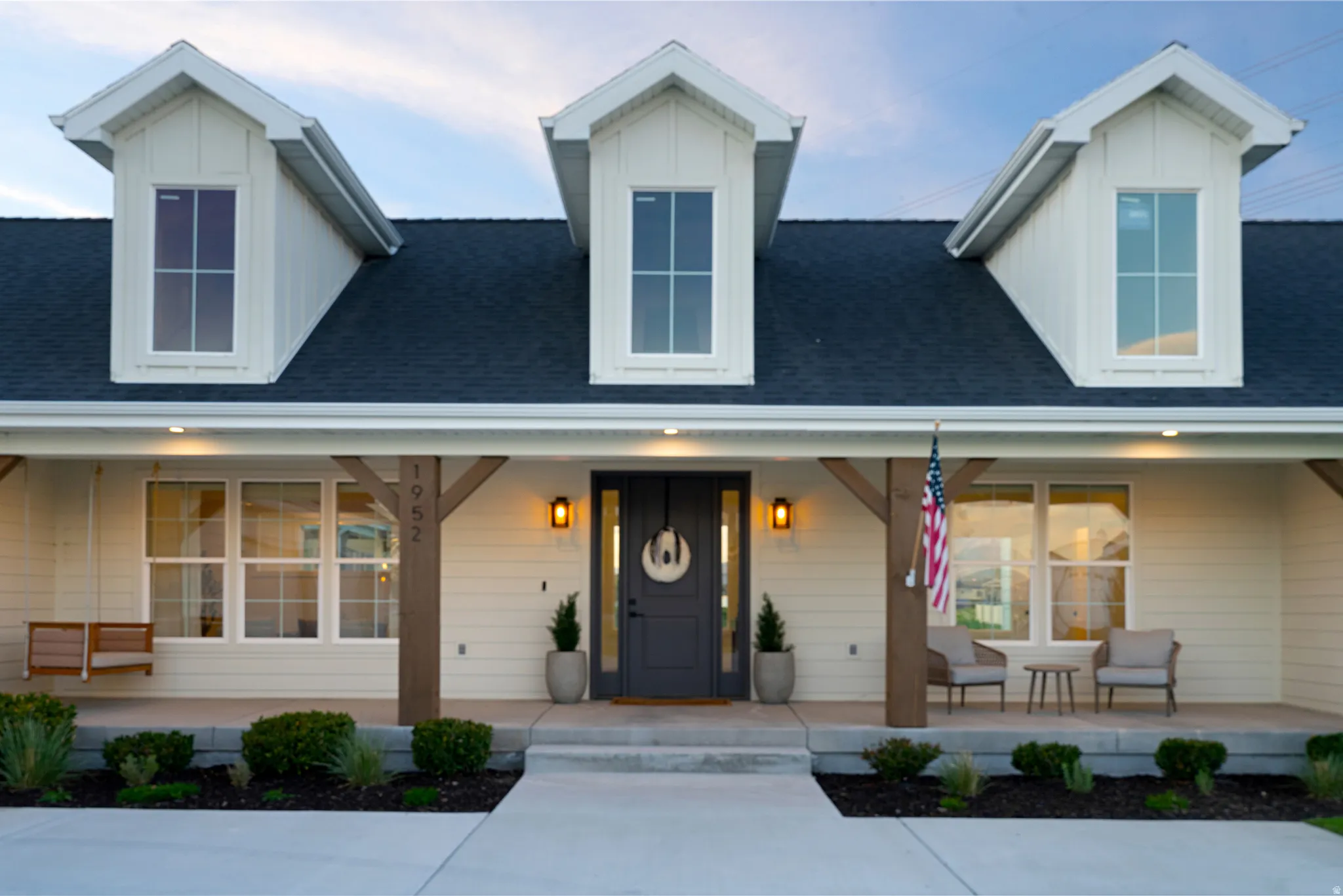 View of front of property with covered porch, a shingled roof, and board and batten siding