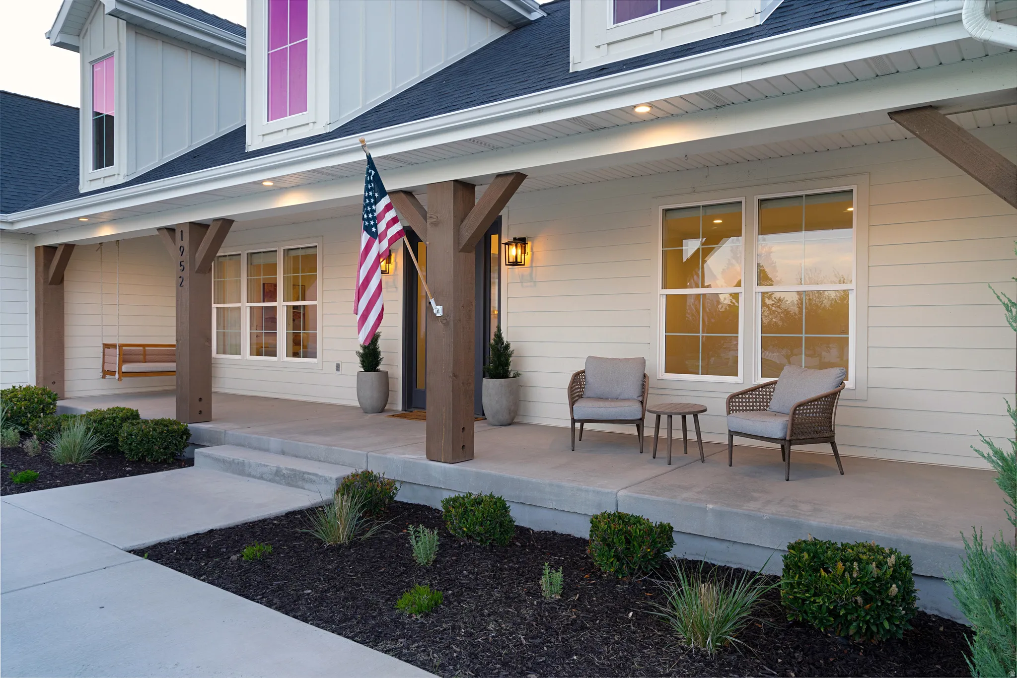 Entrance to property featuring board and batten siding, roof with shingles, and covered porch