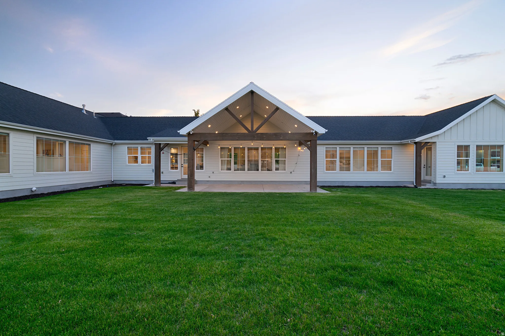 Back of house featuring a patio area, board and batten siding, and a lawn