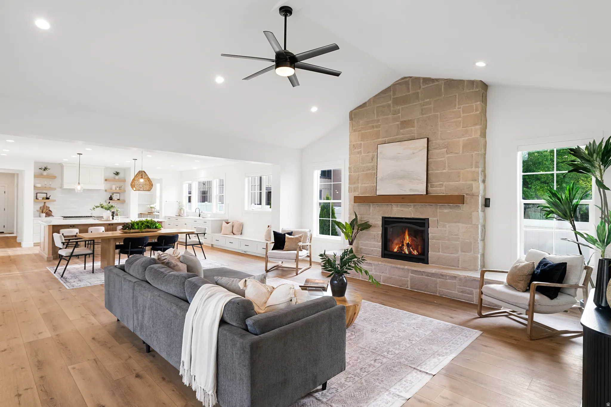 Living room featuring ceiling fan, a fireplace, light wood-type flooring, recessed lighting, and vaulted ceiling