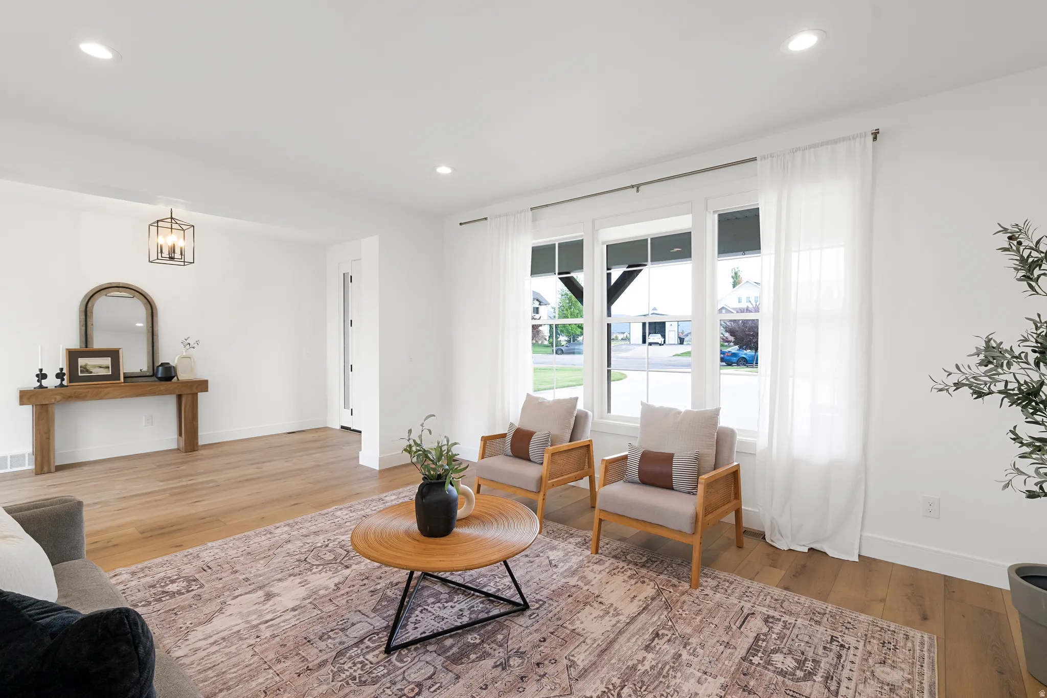 Living area with light wood-type flooring and recessed lighting