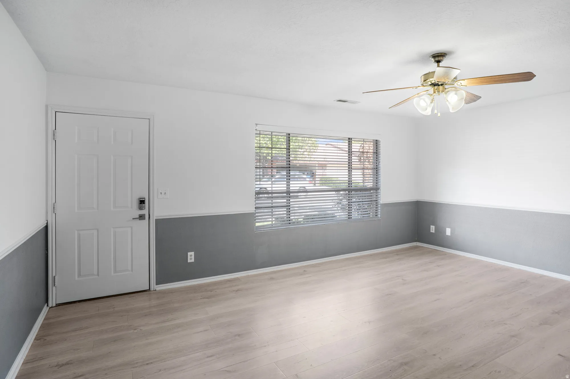 Empty room featuring a ceiling fan and light wood-style flooring