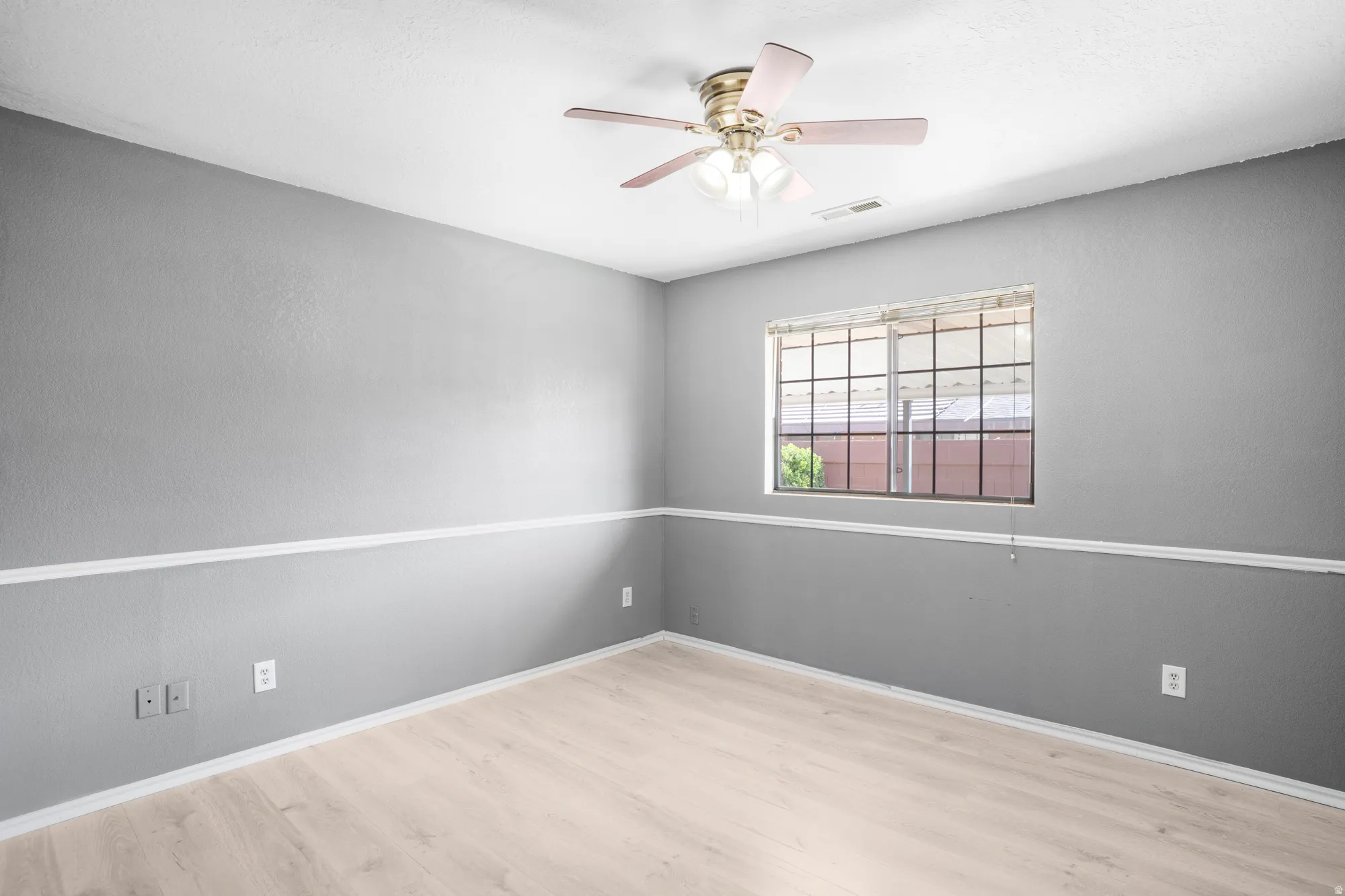 Empty room featuring a ceiling fan and light wood-style flooring